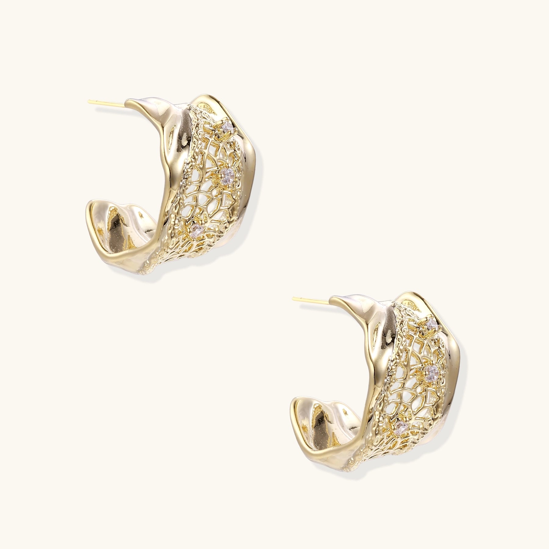 Close-up of gold-plated brass hoop earrings with geometric lattice pattern and sparkling zirconia stones