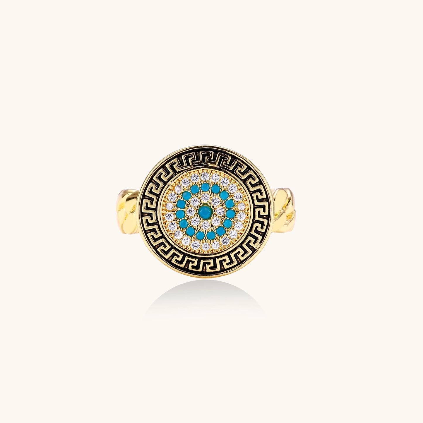 Gold-plated brass ring with Greek key border, evil eye center, and turquoise cubic zirconia stones in chunky chain band style.