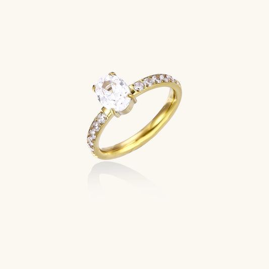 14K gold-plated ring with oval zirconia center stone and pavé band accent stones on white background.