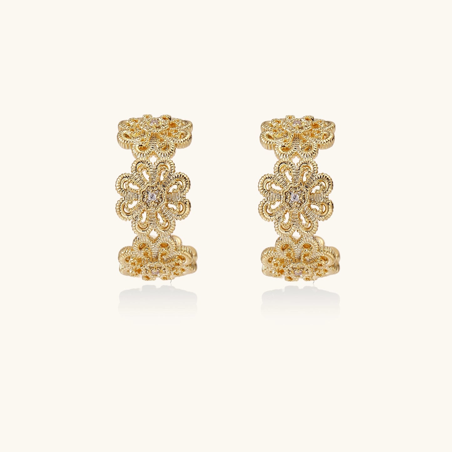 Ornate gold-plated brass hoop earrings featuring delicate floral filigree patterns and intricate rosette details.