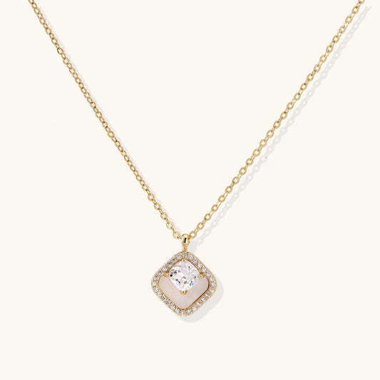 Gold-plated necklace with cushion-shaped pendant featuring a freshwater pearl surrounded by crystal halo on white background.